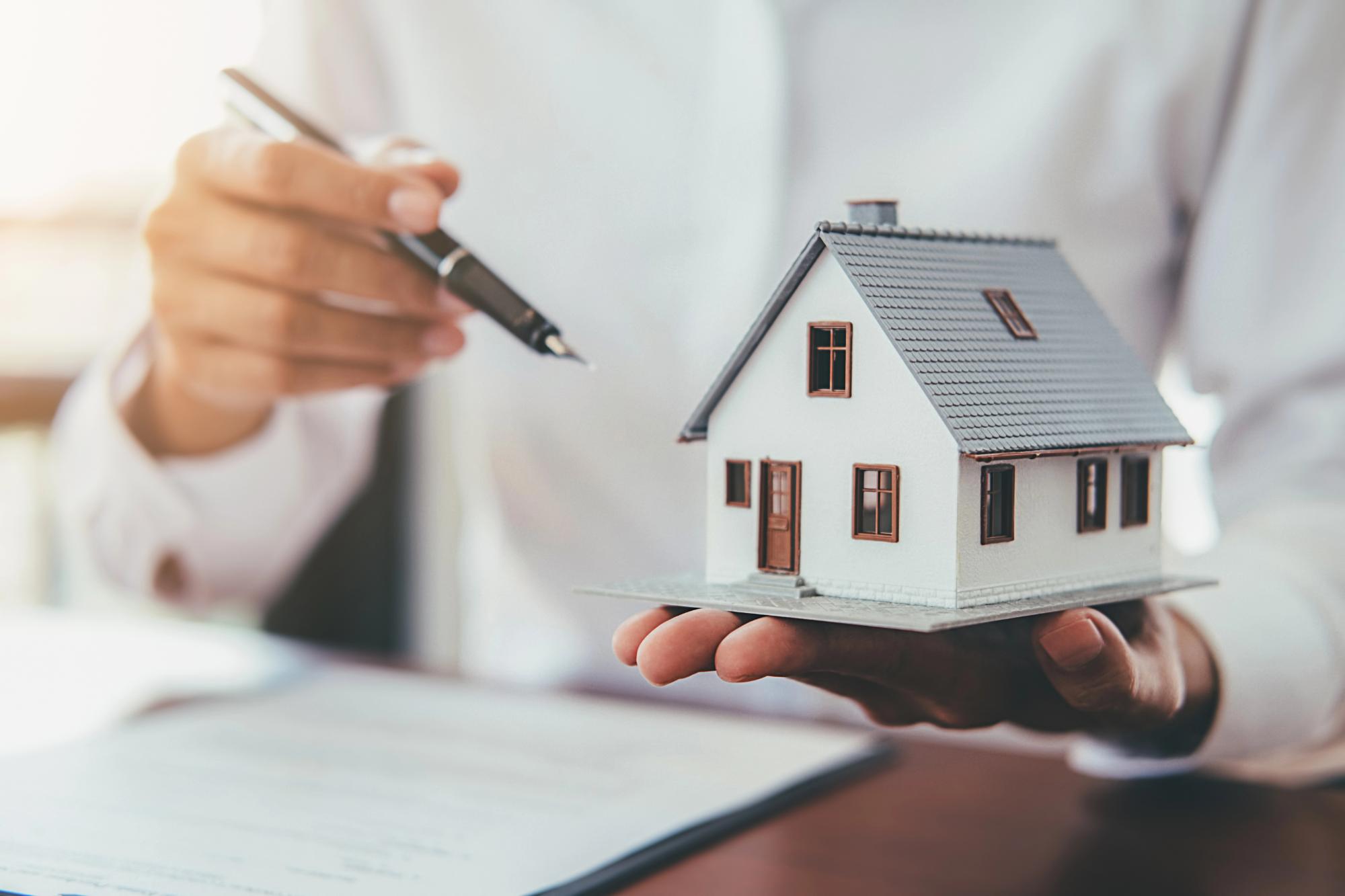House model with real estate agent and customer discussing for contract to buy house House Model Real Estate Agent